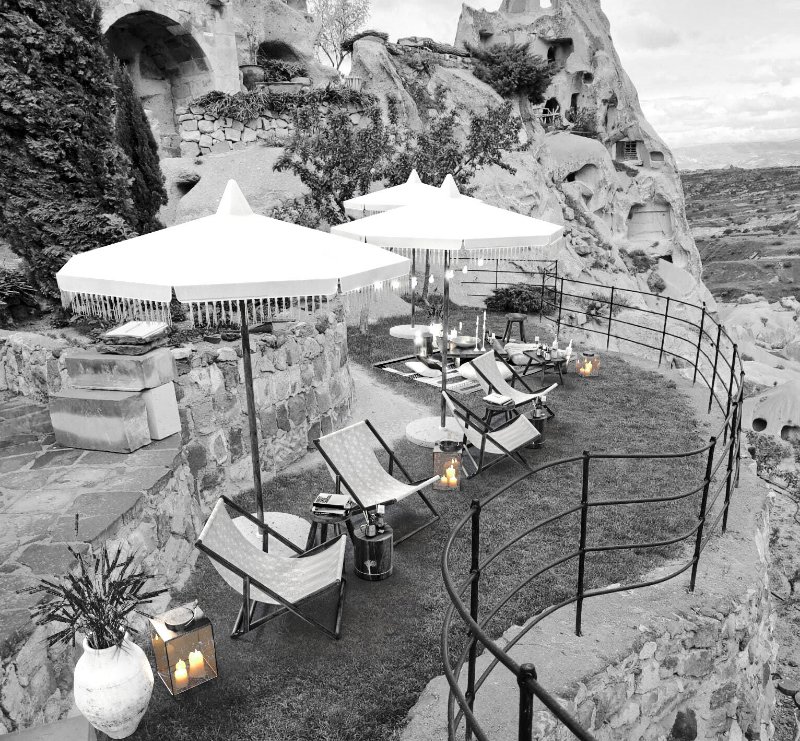 a serene view of a lounge area with natural material seatings white umbrella located in capadoccia turkiye designed for belvedere vodka